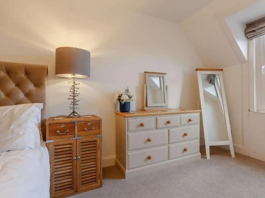 a bedroom with a bed and a dresser and a mirror at 4 Bed in Wick 91390 in Wick