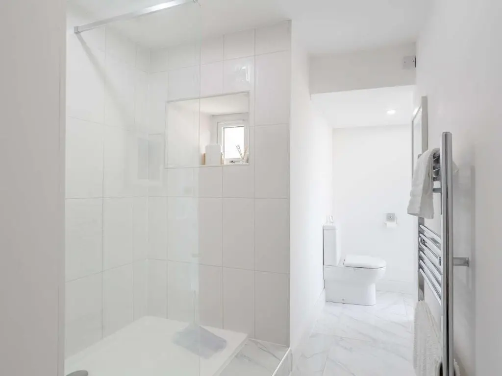 a white bathroom with a shower and a toilet at 4 Bed in Wick 91390 in Wick