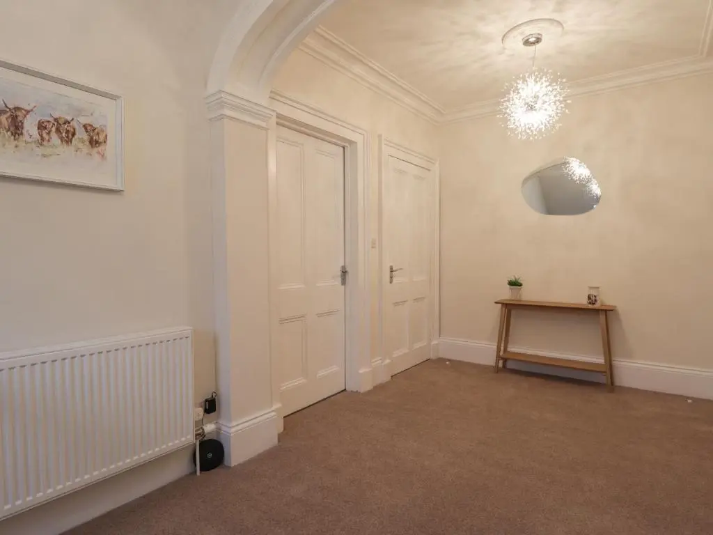a room with a white door and a table at Arden House in Kingussie