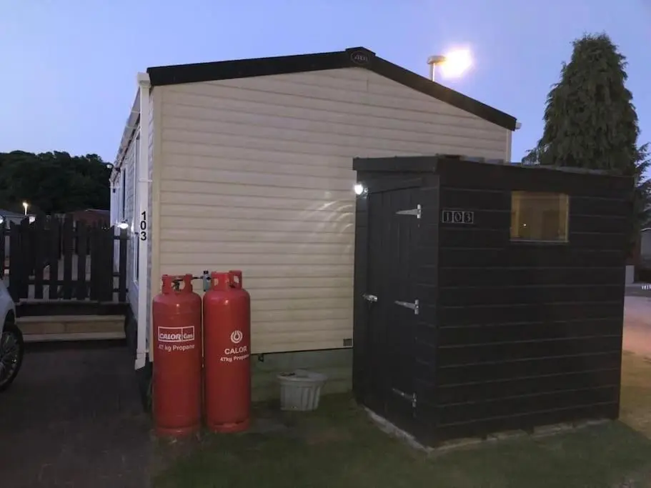 two red fire hydrants sitting next to a garage at Coorie Nook, Chalet 103 in Aviemore