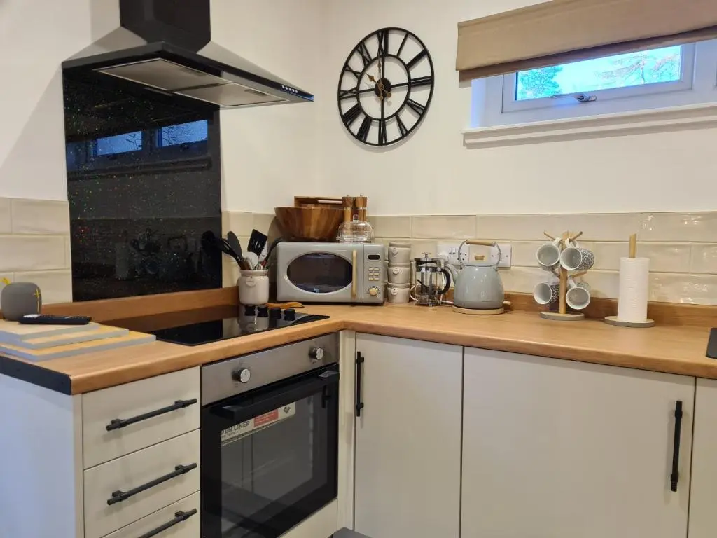 a kitchen with a counter top with a microwave at Findon Nook in Culbokie