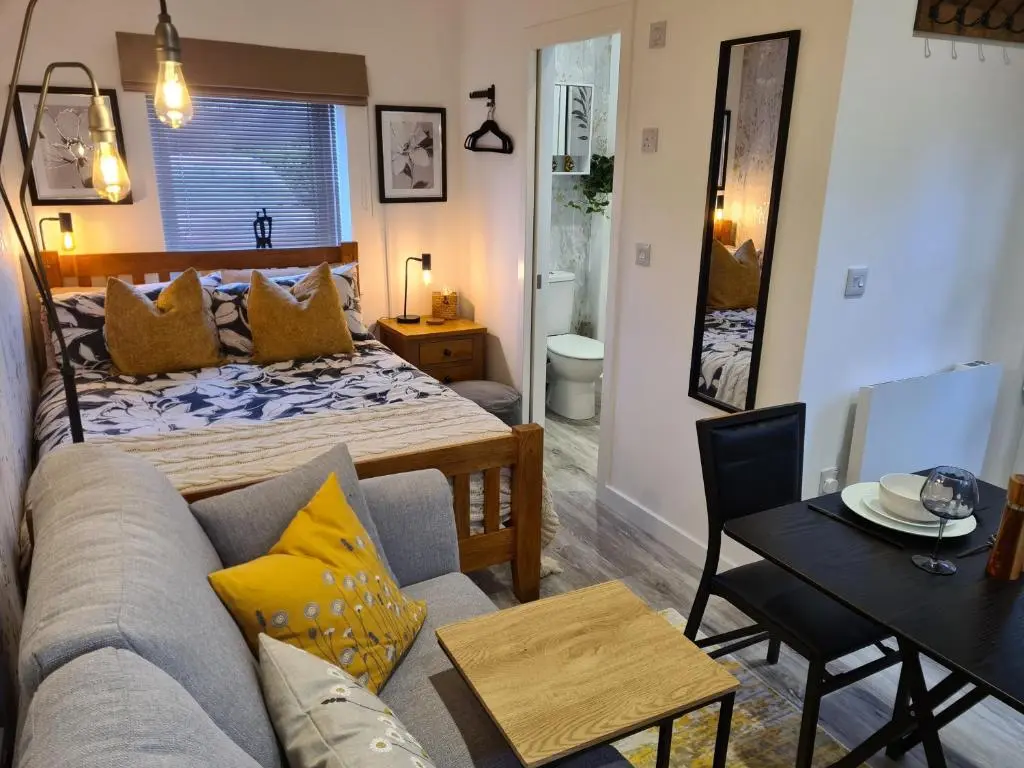 a room with a bed and a couch and a table at Findon Nook in Culbokie