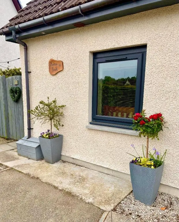 two potted plants on the side of a house at Findon Nook in Culbokie