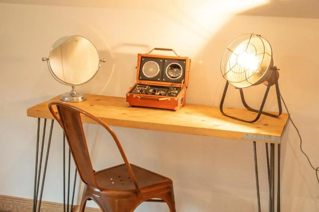 a desk with a radio and a mirror and a chair at Woodhaus Aviemore Lodge in Aviemore