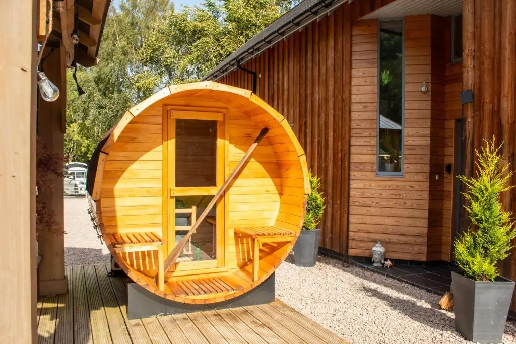 a wooden boat sitting outside of a house at Woodhaus Aviemore Lodge in Aviemore
