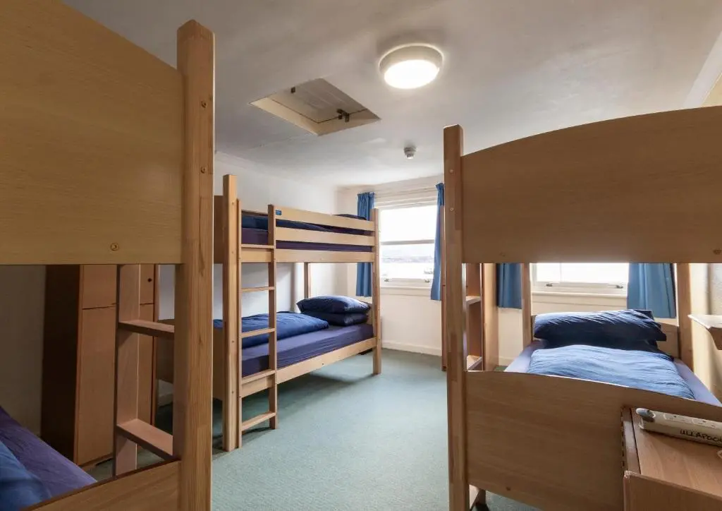 a dorm room with two bunk beds and a hallway at Ullapool Youth Hostel in Ullapool