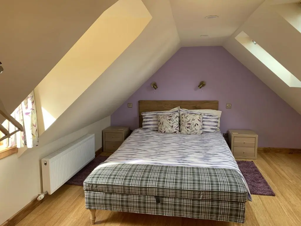 a bedroom with a bed in a attic at Locheil Apartment in Boat of Garten