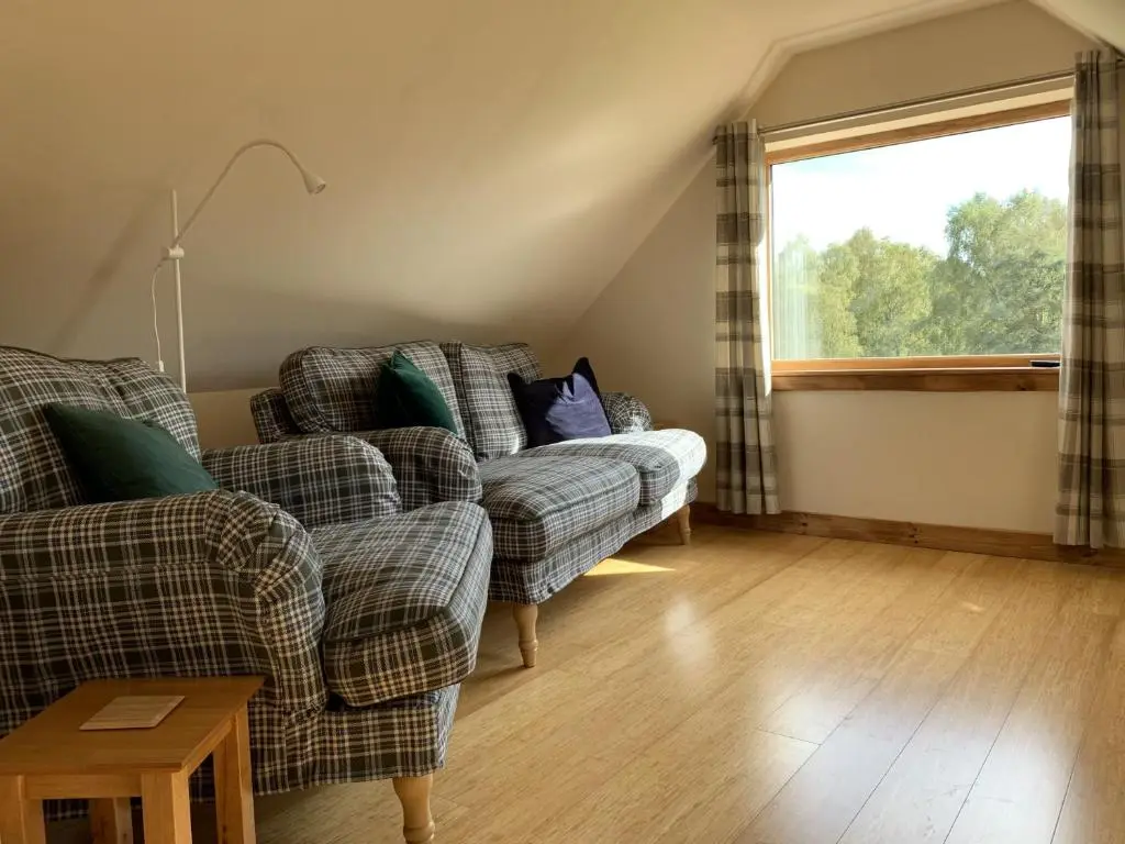 a living room with two couches and a window at Locheil Apartment in Boat of Garten