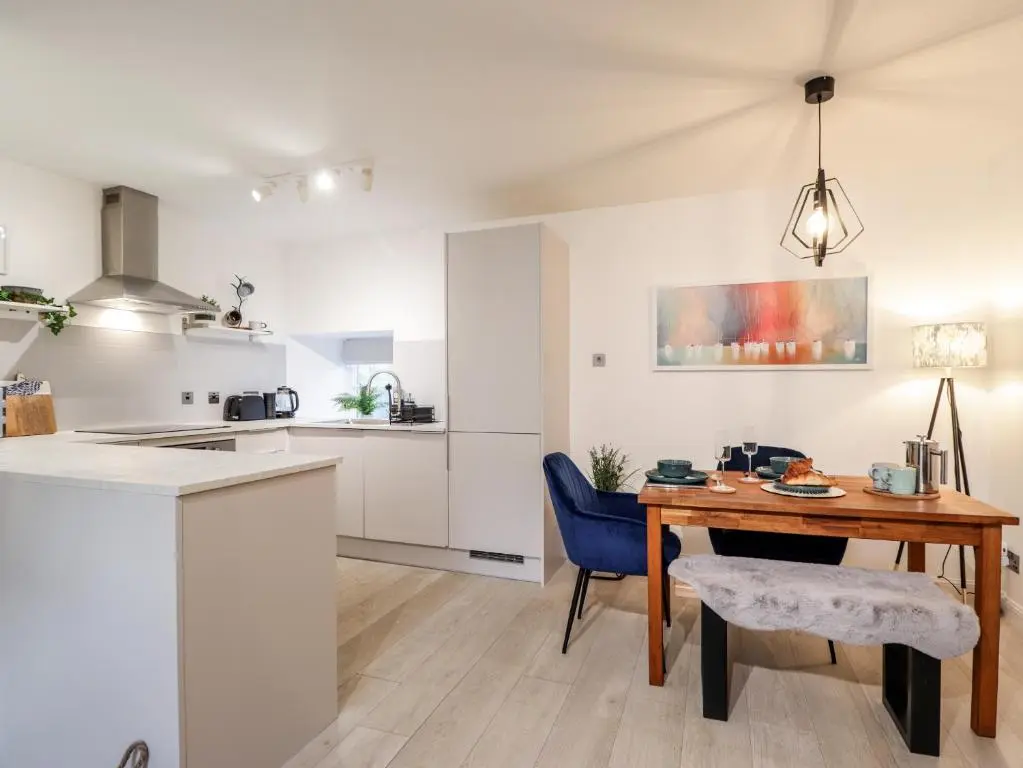 a kitchen and dining room with a wooden table at Flat 4, The Byre in Cromarty