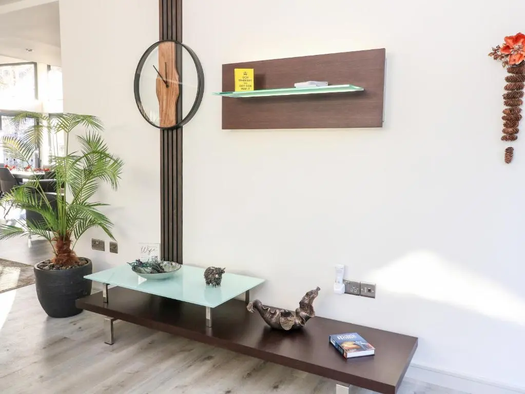 a living room with a table and a shelf at Heilan Roo in Pitlochry