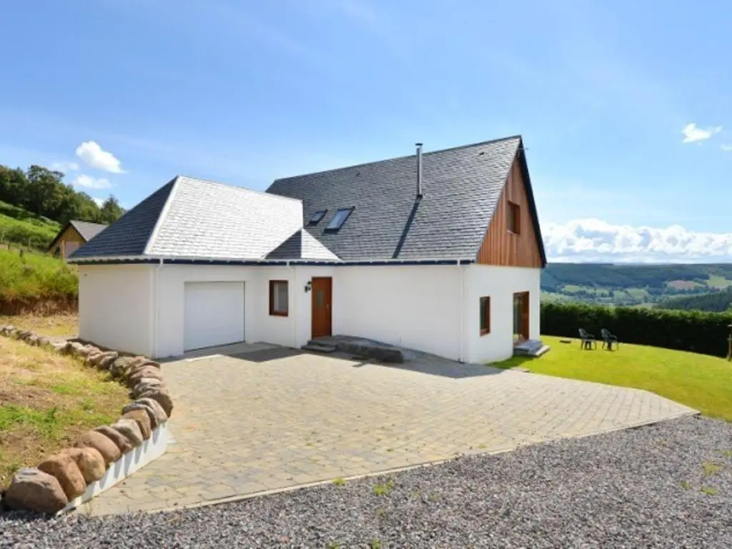 a white house with a gray roof on a hill at Glen View Lodge in Inverness