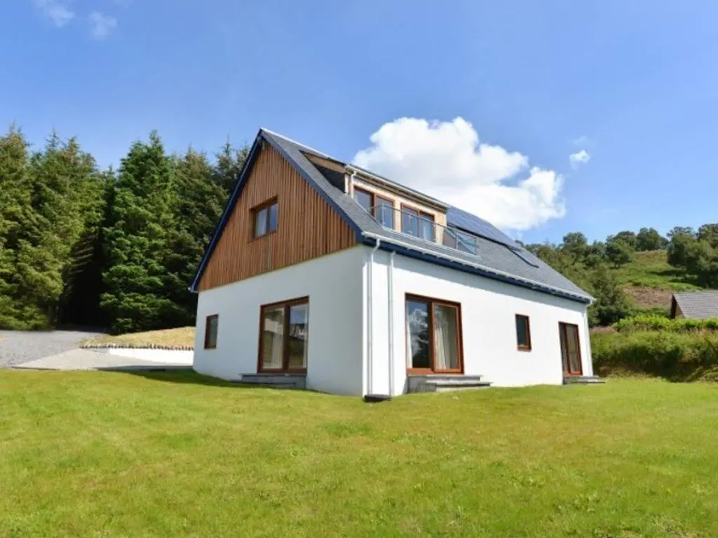 a white house with a gambrel roof at Glen View Lodge in Inverness