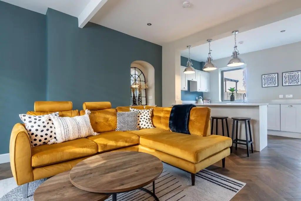 a living room with a yellow couch and a table at Ness at the Park in Inverness