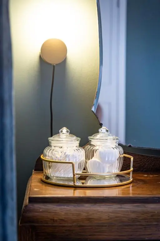 a table with two glass jars and a mirror at Ness at the Park in Inverness