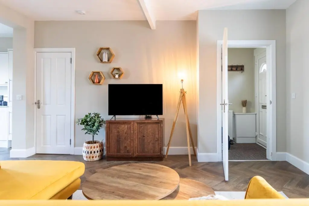 a living room with a flat screen tv and a table at Ness at the Park in Inverness