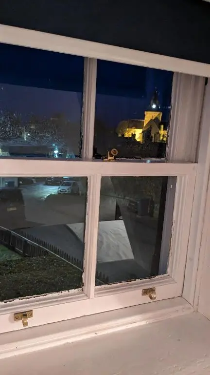 a window with a view of a city at night at Historic character cottage in central Dornoch in Dornoch