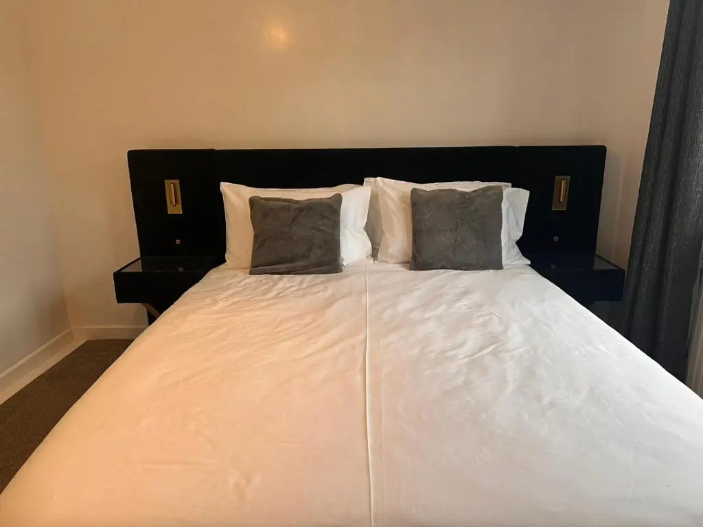 a large white bed with two pillows on it at Shared House in Inverness in Inverness