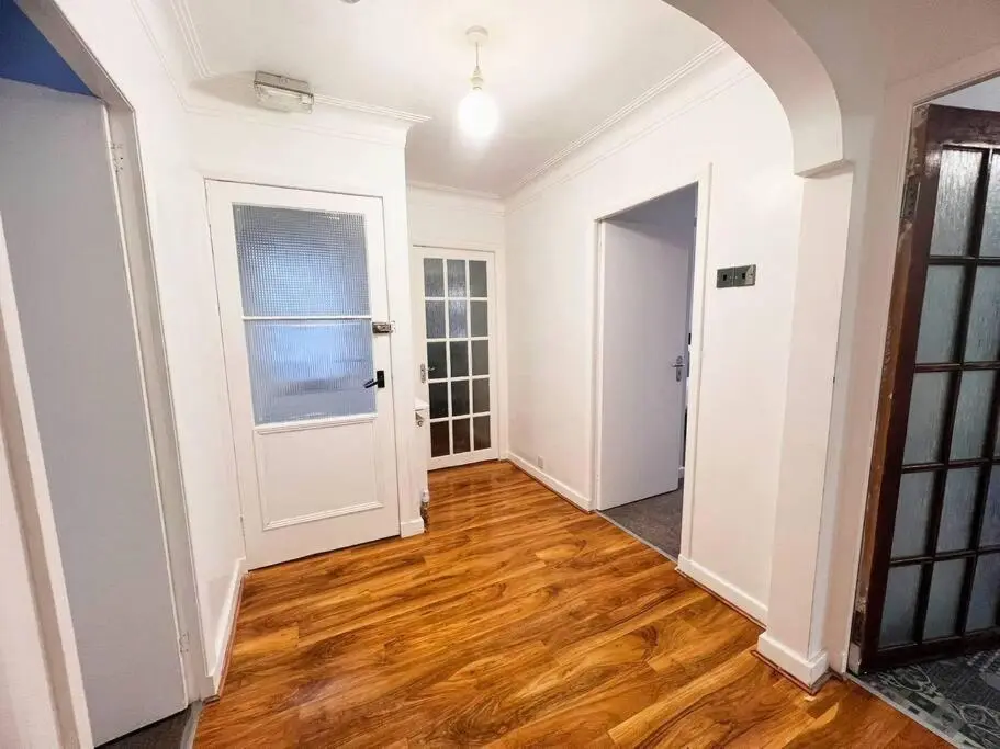 an empty hallway with a door and wooden floors at Shared House in Inverness in Inverness