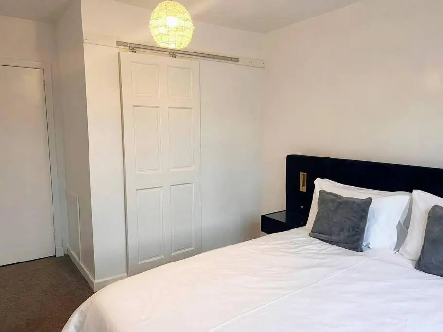 a bedroom with a white bed and a white door at Shared House in Inverness in Inverness