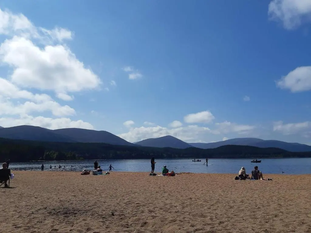 a group of people on a beach near the water at Cedar Cottage - Uk32633 in Grantown on Spey