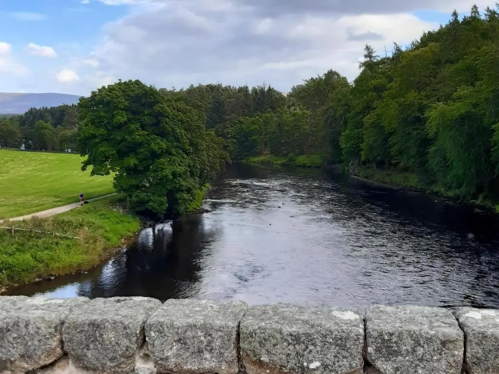 a view of a river from a stone wall at Cedar Cottage - Uk32633 in Grantown on Spey