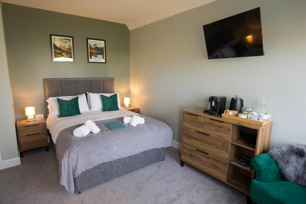a bedroom with a bed and a flat screen tv at The Crossing in Kingussie