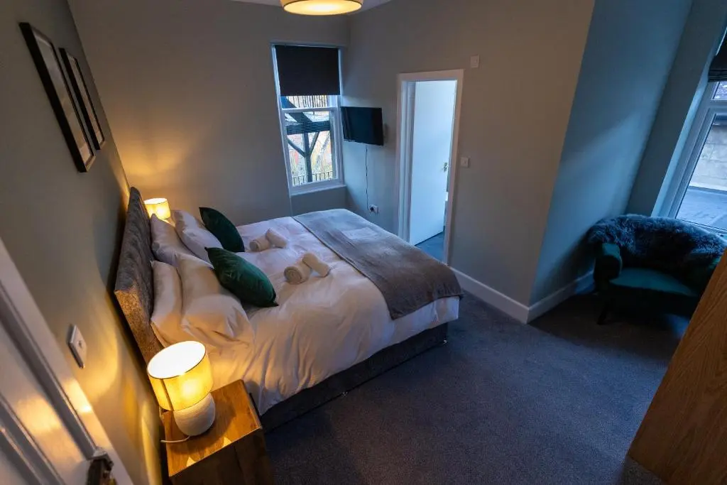 a bedroom with a large bed and a chair at The Crossing in Kingussie