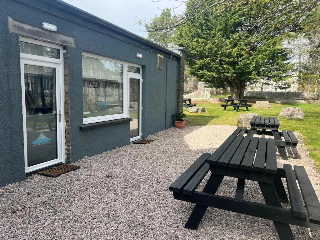 a picnic bench next to a blue building at The Crossing in Kingussie