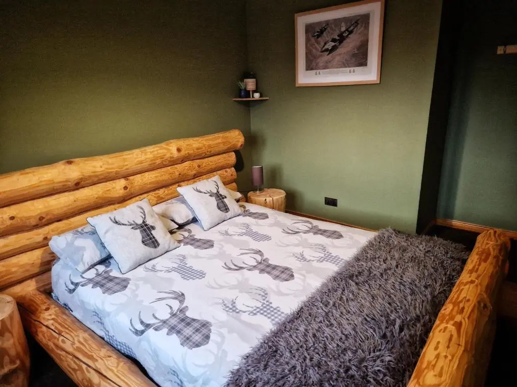 a bedroom with a wooden bed with pillows on it at Mountain View No12 in Aviemore