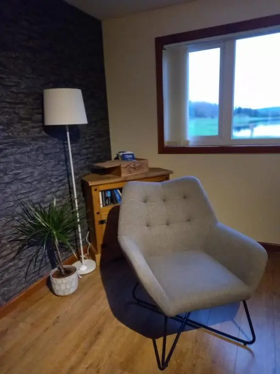 a living room with a chair and a lamp at The Boathouse in Longmorn