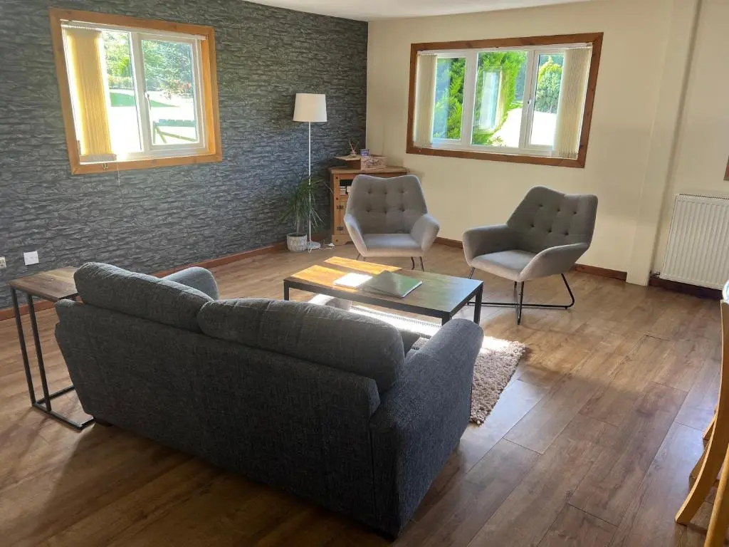 a living room with a couch and two chairs at The Boathouse in Longmorn