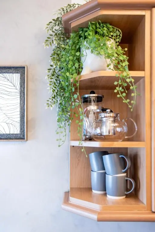 a wooden shelf with cups and plants on it at The Tartan Terrace in Inverness