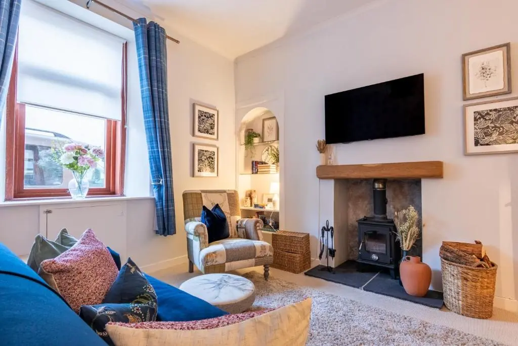 a living room with a blue couch and a fireplace at The Tartan Terrace in Inverness
