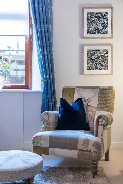 a living room with a chair and a blue pillow at The Tartan Terrace in Inverness