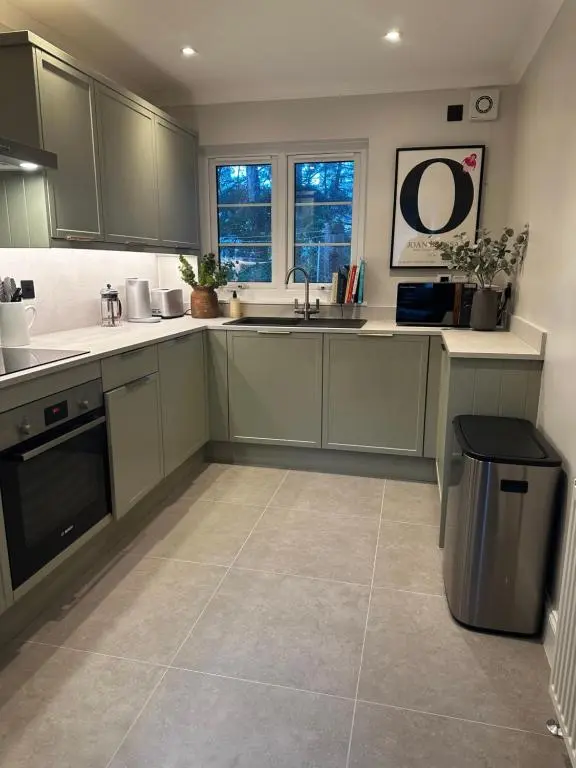 a kitchen with green cabinets and a tile floor at Findhorn Lodge in Findhorn