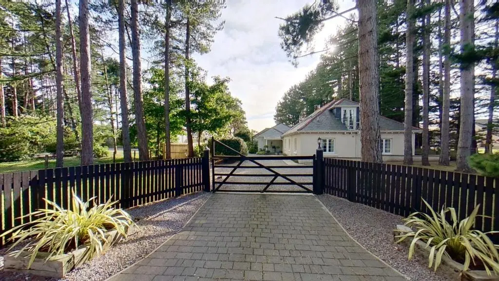 a black fence with a gate in front of a house at Findhorn Lodge in Findhorn