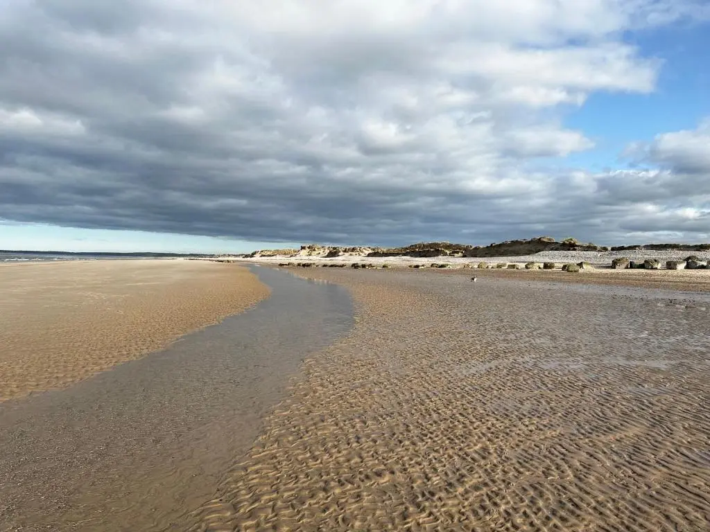 a sandy beach with footprints in the sand at Findhorn Lodge in Findhorn