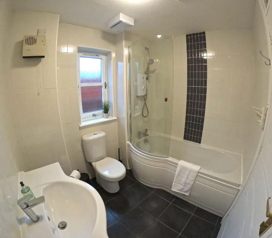 a bathroom with a shower toilet and a sink at Orange Squirrel Lodge in Aviemore