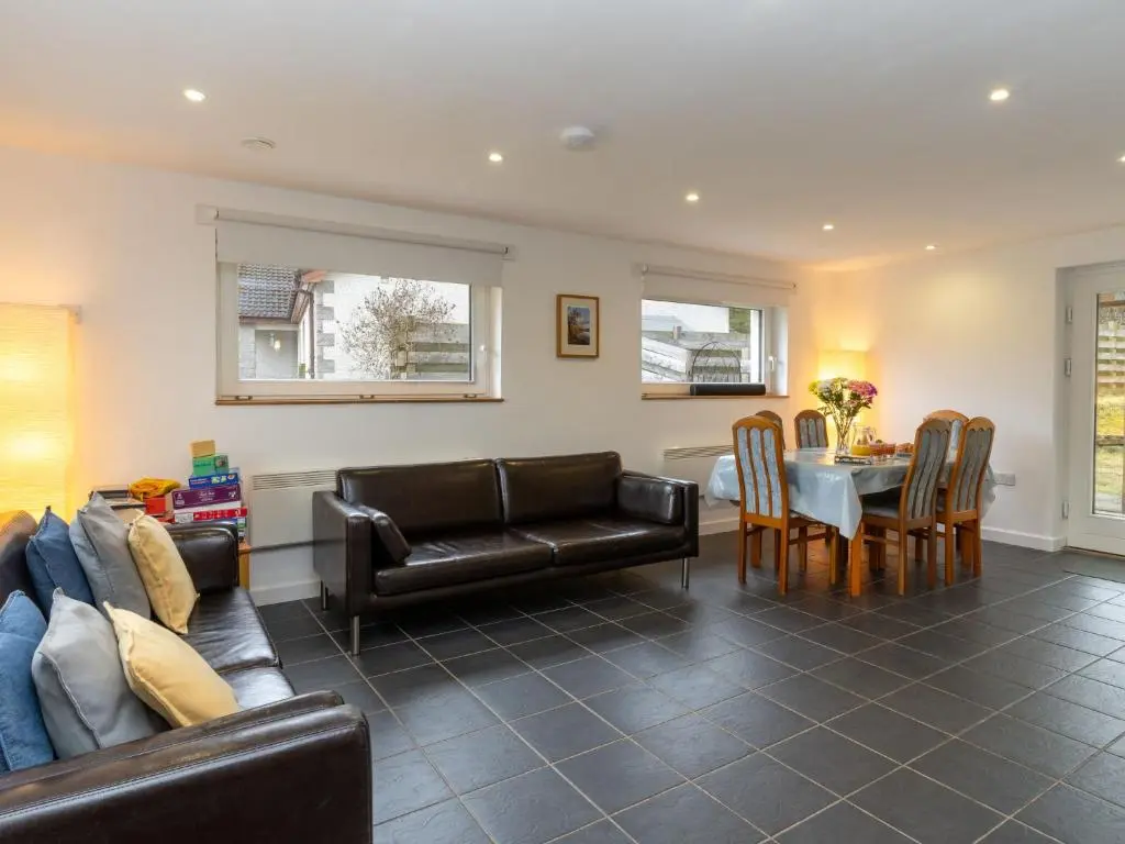 a living room with a couch and a table at Holiday Home Muir Edge by Interhome in Nethy Bridge