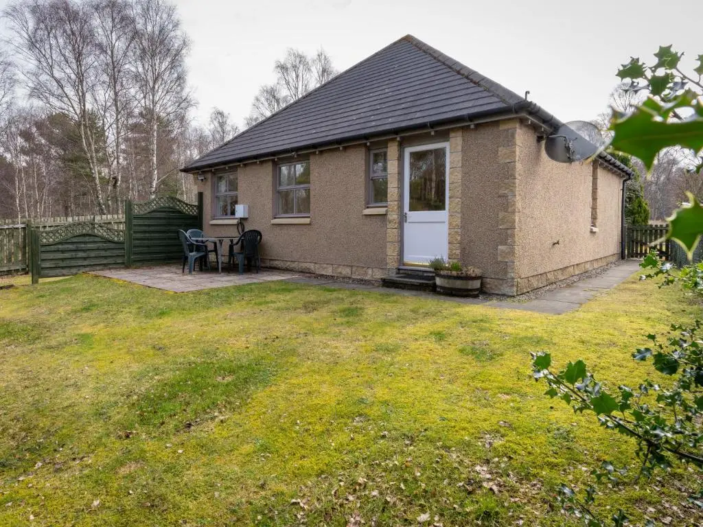 a small house with a patio and a yard at Holiday Home Falcon Lodge by Interhome in Aviemore