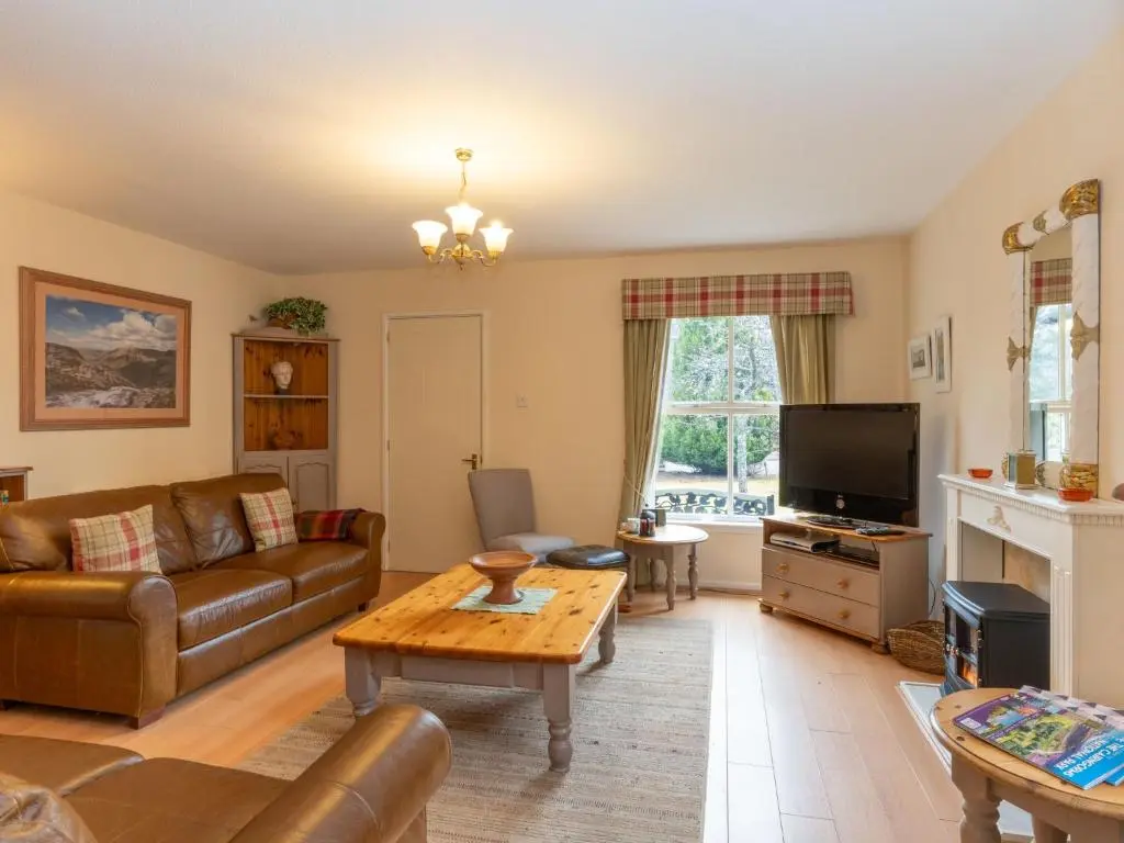a living room with a couch and a table at Holiday Home Falcon Lodge by Interhome in Aviemore
