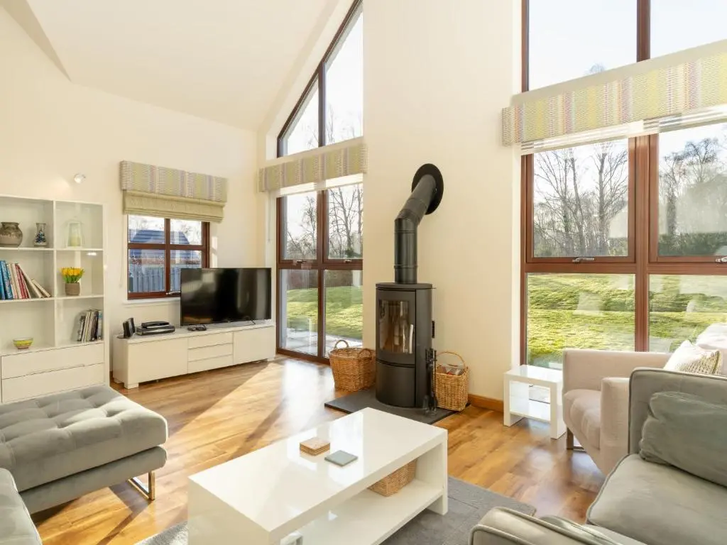 a living room with a fireplace and a tv at Villa Pineways by Interhome in Aviemore