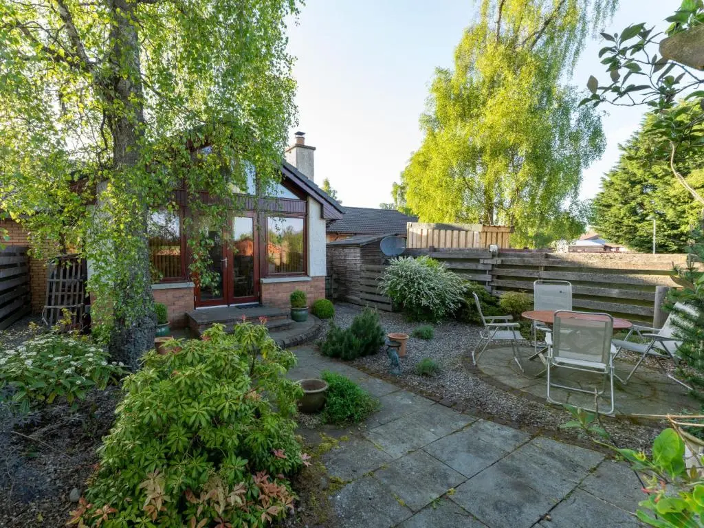 a patio with a table and chairs in a yard at Holiday Home Skye Premier by Interhome in Aviemore