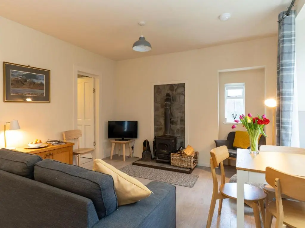 a living room with a couch and a fire place at Holiday Home 2 Railway Cottage by Interhome in Aviemore