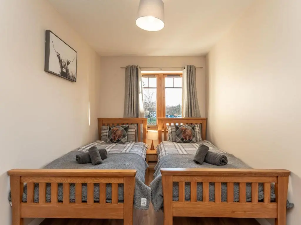 two twin beds in a room with a window at Apartment The Bruach by Interhome in Aviemore