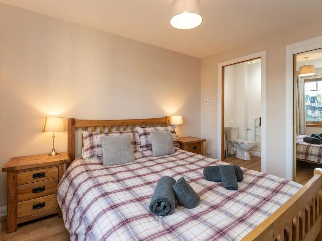 a bedroom with a bed with pillows on it at Apartment The Bruach by Interhome in Aviemore
