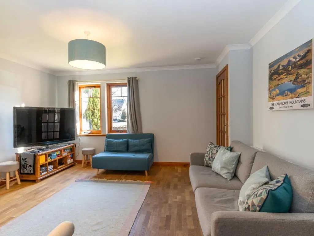 a living room with a couch and a tv at Holiday Home Cosagach Cottage by Interhome in Aviemore