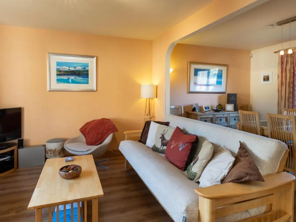 a living room with a couch and a table at Holiday Home Braeriach by Interhome in Aviemore