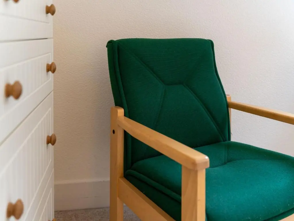 a green chair sitting in a corner of a room at Holiday Home 1 Railway Cottage by Interhome in Aviemore