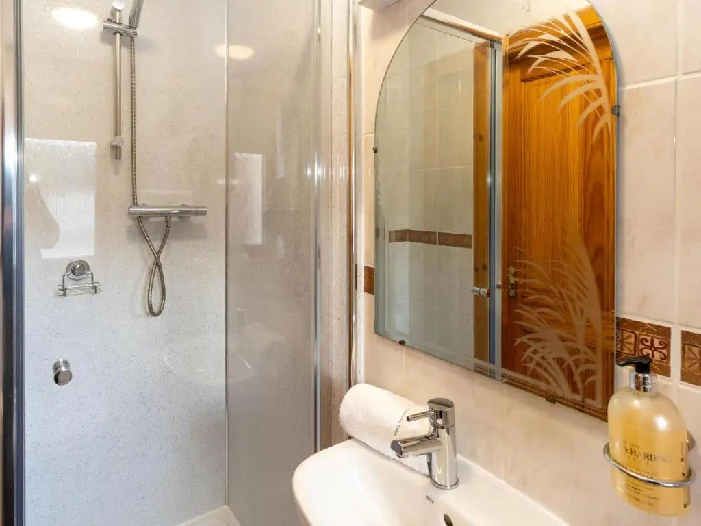 a bathroom with a shower and a sink and a mirror at Villa Craigmore Lodge by Interhome in Aviemore
